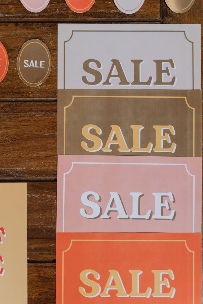 Colorful sale signs arranged on a wooden surface, ideal for promotions.